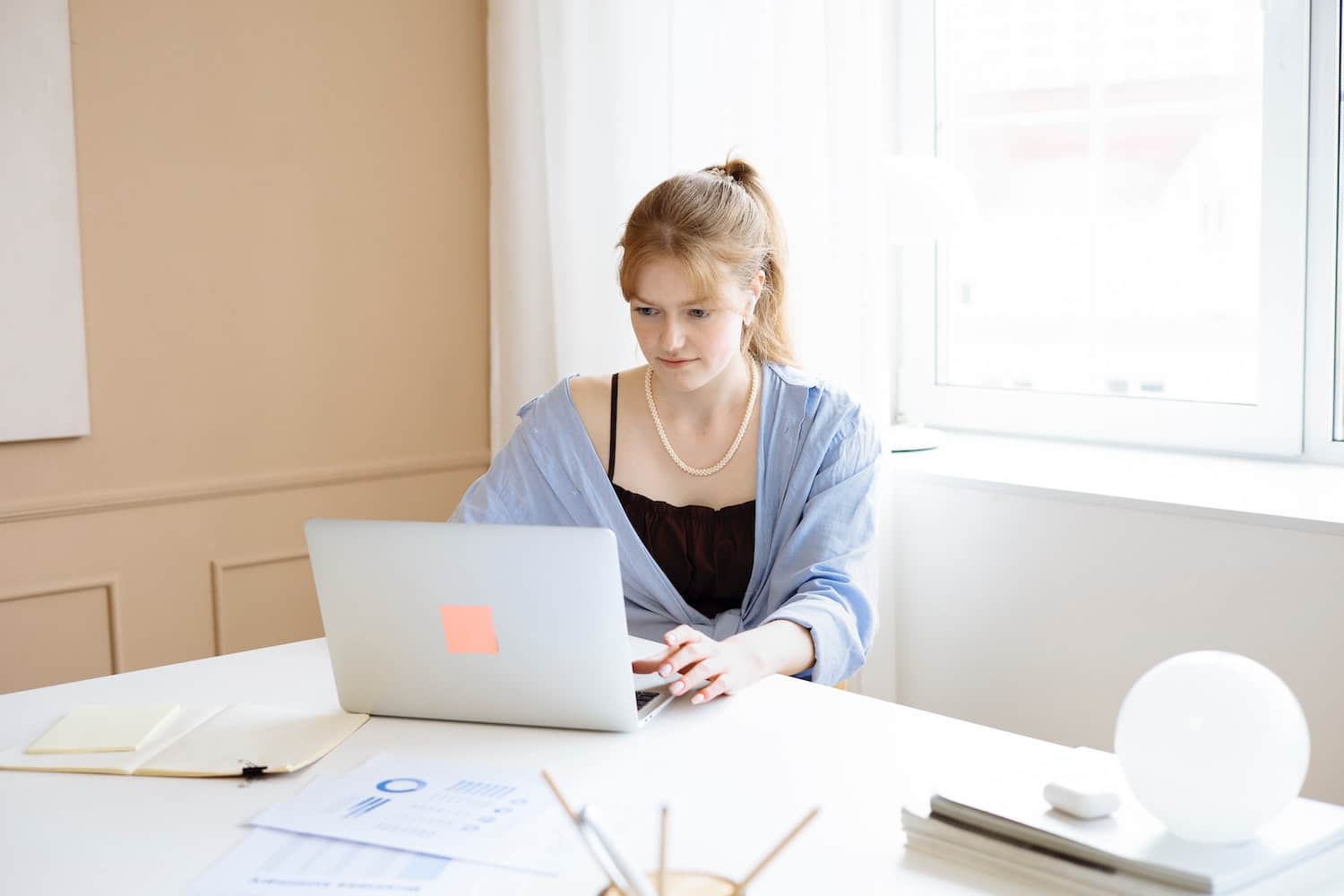 a woman on her laptop researching the steps of how to become a brand ambassador