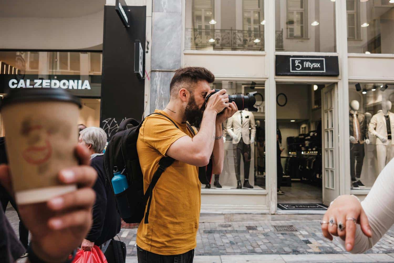 A man taking pictures to engage in hyperlocal social media marketing.