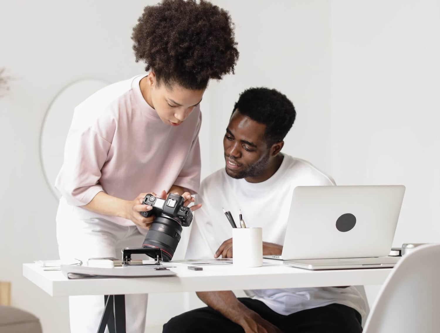 Two people reviewing photos on a camera to help them learn what is a digital creator.